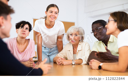 Group of mixed age people communicating in English-speaking club with young female tutor Group of mixed age people communicating in English-speaking club with young female tutor 112822844