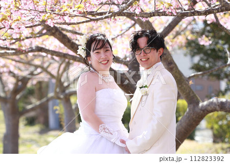 河津桜をバックにウエディングドレス姿の新婦様フォトウエディングロケーション撮影ブライダルフォト 112823392