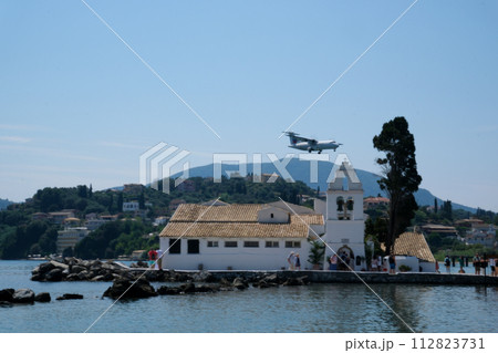 Monastery on the water, over which planes take off and land Greece Corfu island Vlacherna Monastery  112823731
