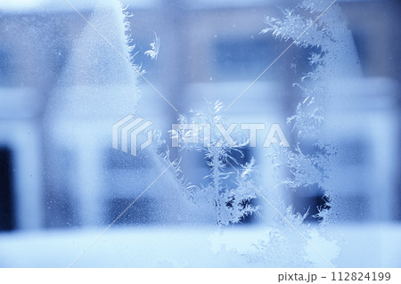 Close up of an abstract frosty blurred patterns on the window, glass. Blue ice winter background, natural texture with copy space. 112824199
