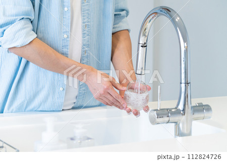 キッチンでコップを洗う若い男性の手元 112824726