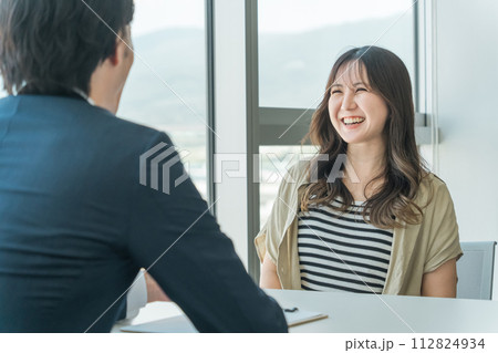 投資信託・マネー相談・個別相談を受ける若いアジア人女性とカウンセリングするビジネスマン男性 112824934