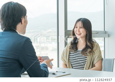 投資信託・マネー相談・個別相談を受ける若いアジア人女性とカウンセリングするビジネスマン男性 投資信託・マネー相談・個別相談を受ける若いアジア人女性とカウンセリングするビジネスマン男性 112824937