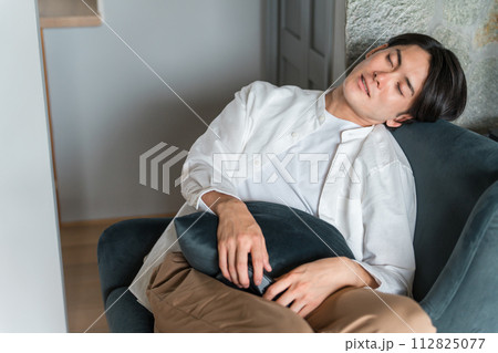 ソファで仮眠・うたた寝する若い男性(昼寝・睡眠・シエスタ・パワーナップ) ソファで仮眠・うたた寝する若い男性(昼寝・睡眠・シエスタ・パワーナップ) 112825077