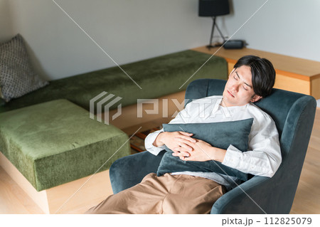 ソファで仮眠・うたた寝する若い男性（昼寝・睡眠・シエスタ・パワーナップ） 112825079