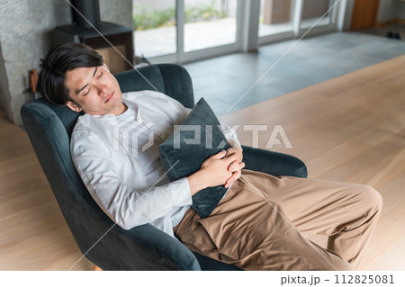 ソファで仮眠・うたた寝する若い男性（昼寝・睡眠・シエスタ・パワーナップ） 112825081