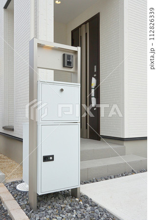 住宅の玄関に設置された宅配ボックス 112826339