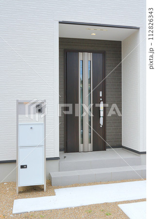 住宅の玄関に設置された宅配ボックス 112826343