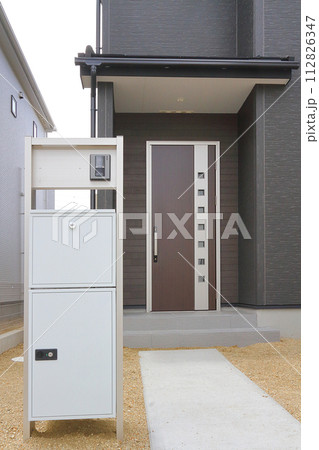 住宅の玄関に設置された宅配ボックス 112826347