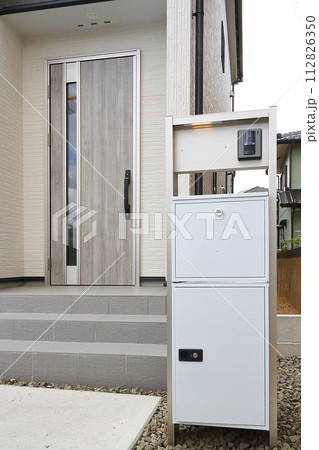 住宅の玄関に設置された宅配ボックス 112826350