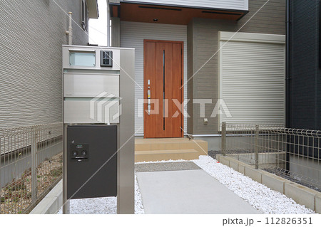 住宅の玄関に設置された宅配ボックス 112826351