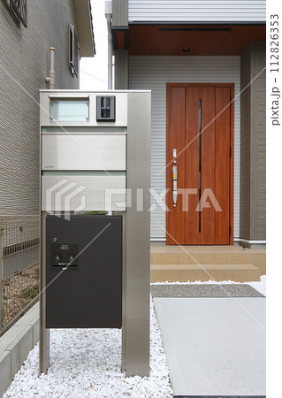 住宅の玄関に設置された宅配ボックス 112826353
