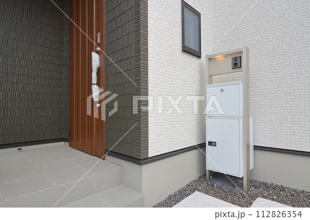 住宅の玄関に設置された宅配ボックス 112826354