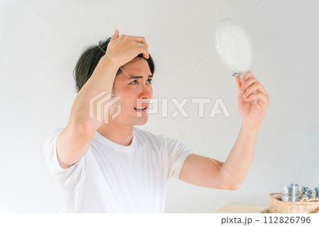 薄毛・脱毛・AGA・抜け毛・頭皮・セルフケア前髪・髪の毛のことで悩む若い男性（薄毛治療） 112826796