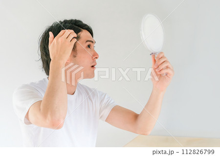 薄毛・脱毛・AGA・抜け毛・頭皮・セルフケア前髪・髪の毛のことで悩む若い男性（薄毛治療） 112826799