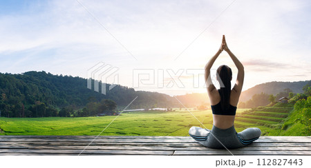 Asian woman doing yoga on the wooden balcony 112827443