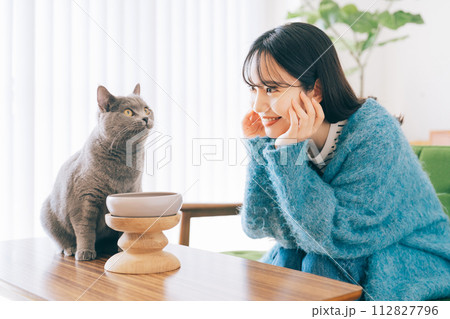 猫にごはんをあげる女性 112827796
