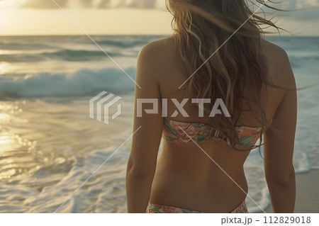 Beach Bliss: Rear View of Woman in Bikini Embracing Coastal Serenity Beach Bliss: Rear View of Woman in Bikini Embracing Coastal Serenity 112829018