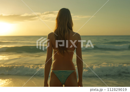 Beach Bliss: Rear View of Woman in Bikini Embracing Coastal Serenity Beach Bliss: Rear View of Woman in Bikini Embracing Coastal Serenity 112829019