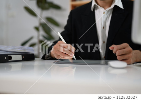Unrecognizable businessman signing contract or writing important notes on digital tablet Unrecognizable businessman signing contract or writing important notes on digital tablet 112832627