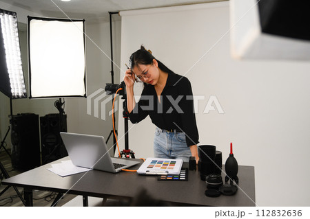 Frustrated female photographer working at her studio 112832636