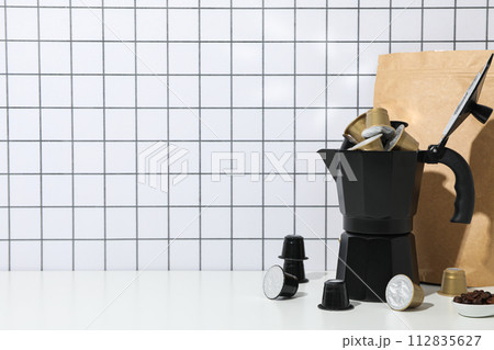 Coffee capsules, coffee maker and paper bag on light background, space for text 112835627