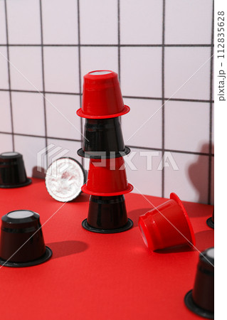 Coffee capsules on red table on light background 112835628