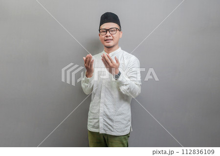 Asian Muslim man standing looking empty space happily to show grateful 112836109