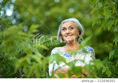 Portrait of senior woman in summer park 112836281
