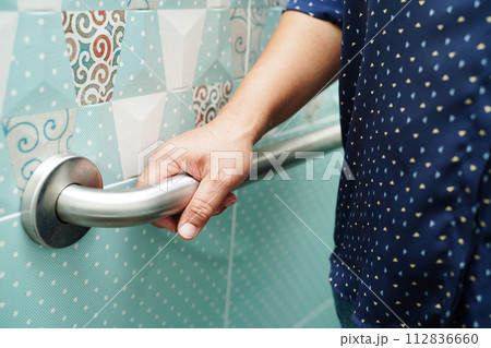 Asian woman patient use toilet support rail in bathroom, handrail safety grab bar, security in nursing hospital. Asian woman patient use toilet support rail in bathroom, handrail safety grab bar, security in nursing hospital. 112836660