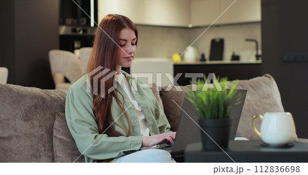 Businesswoman works from home using computer. Young woman freelancer working remote typing on laptop. Distance work concept. Businesswoman works from home using computer. Young woman freelancer working remote typing on laptop. Distance work concept. 112836698