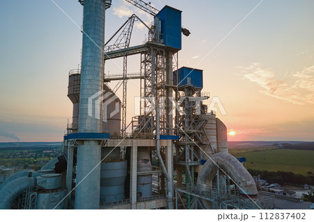 Cement plant with high factory structure and tower cranes at industrial production area. Manufacture, global industry and air pollution concept 112837402