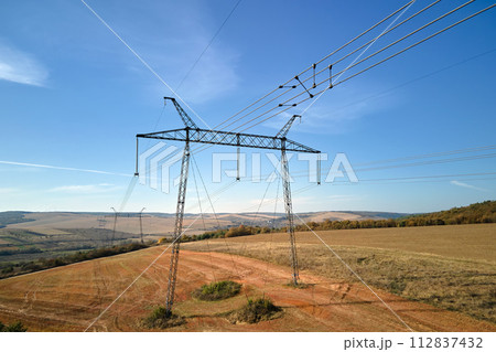 Steel pillar with high voltage electric power lines delivering electrical energy through cable wires on long distance Steel pillar with high voltage electric power lines delivering electrical energy through cable wires on long distance 112837432