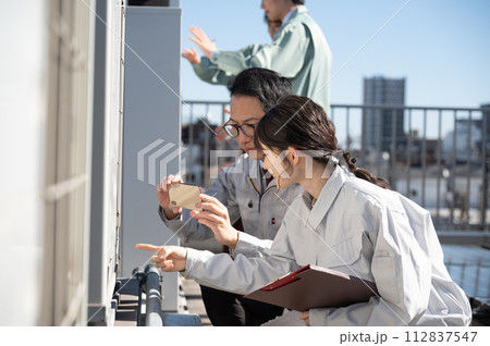 現地調査する男女の若い空調エンジニア 112837547