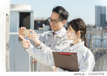 現地調査する男女の若い空調エンジニア 112837550