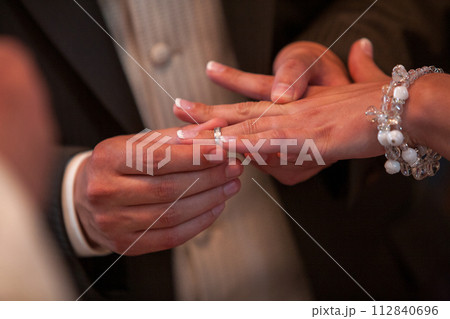 Vows Exchanged: The Tender Moment of Ring Placement During a Wedding Ceremony Vows Exchanged: The Tender Moment of Ring Placement During a Wedding Ceremony 112840696