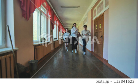 The students are running down the hallway of the school. The students are running down the hallway of the school. 112841622
