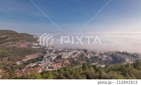 Panorama showing aerial View of Sesimbra Town and Port covered by fog timelapse, Portugal. 112841813