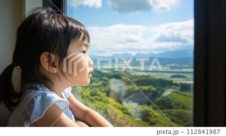 child gazing out the train window, their face pressed against the glass 112841987