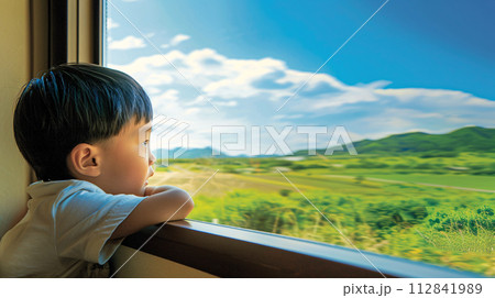 child gazing out the train window, their face pressed against the glass 112841989