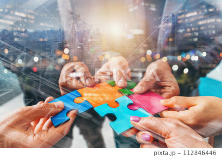 Businessmen working together to build a puzzle as teamwork, partnership and integration concept 112846446