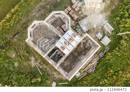 Aerial view of building site for future house, brick basement floor and stacks of brick for construction. Aerial view of building site for future house, brick basement floor and stacks of brick for construction. 112846472
