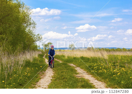Boy on bike on country road in sunny day Boy on bike on country road in sunny day 112847280