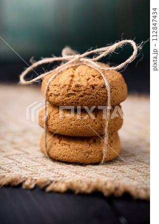Oatmeal cookies tied with a rope on a wooden table. The concept of food for breakfast 112847434