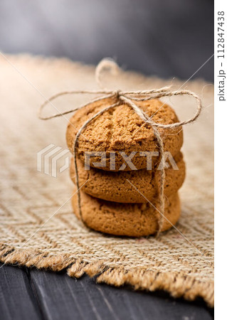 Oatmeal cookies tied with a rope on a wooden table. The concept of food for breakfast 112847438