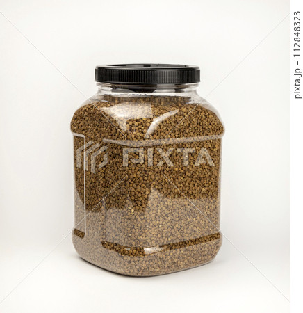 Buckwheat groats, in a cereal storage container. Plastic container with buckwheat. Buckwheat groats, in a cereal storage container. Plastic container with buckwheat. 112848323