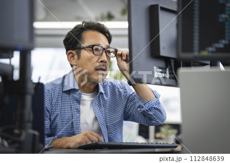 パソコンのモニタを見つめる50代の男性 112848639