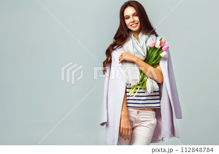 Fashion photo of beautiful woman with tulips in her hand. March 8. beautiful girl in stylish clothes 112848784