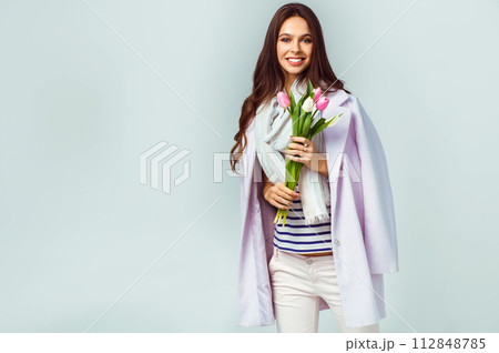 Fashion photo of beautiful woman with tulips in her hand. March 8. beautiful girl in stylish clothes 112848785