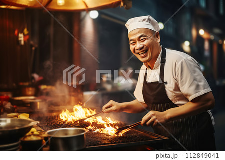 AI-generated content. Happy Asian chef cooking traditional food on open fire in street market 112849041